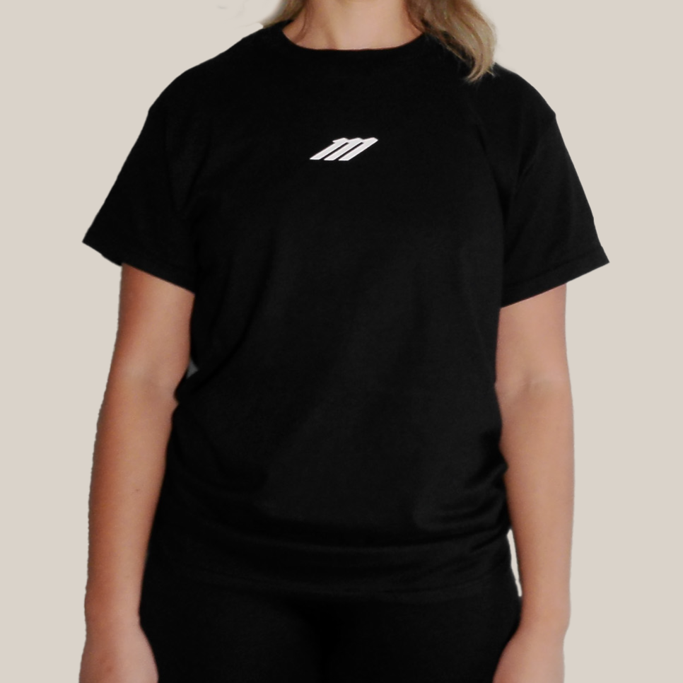 Person wearing a Motion black t-shirt with a logo on a beige background