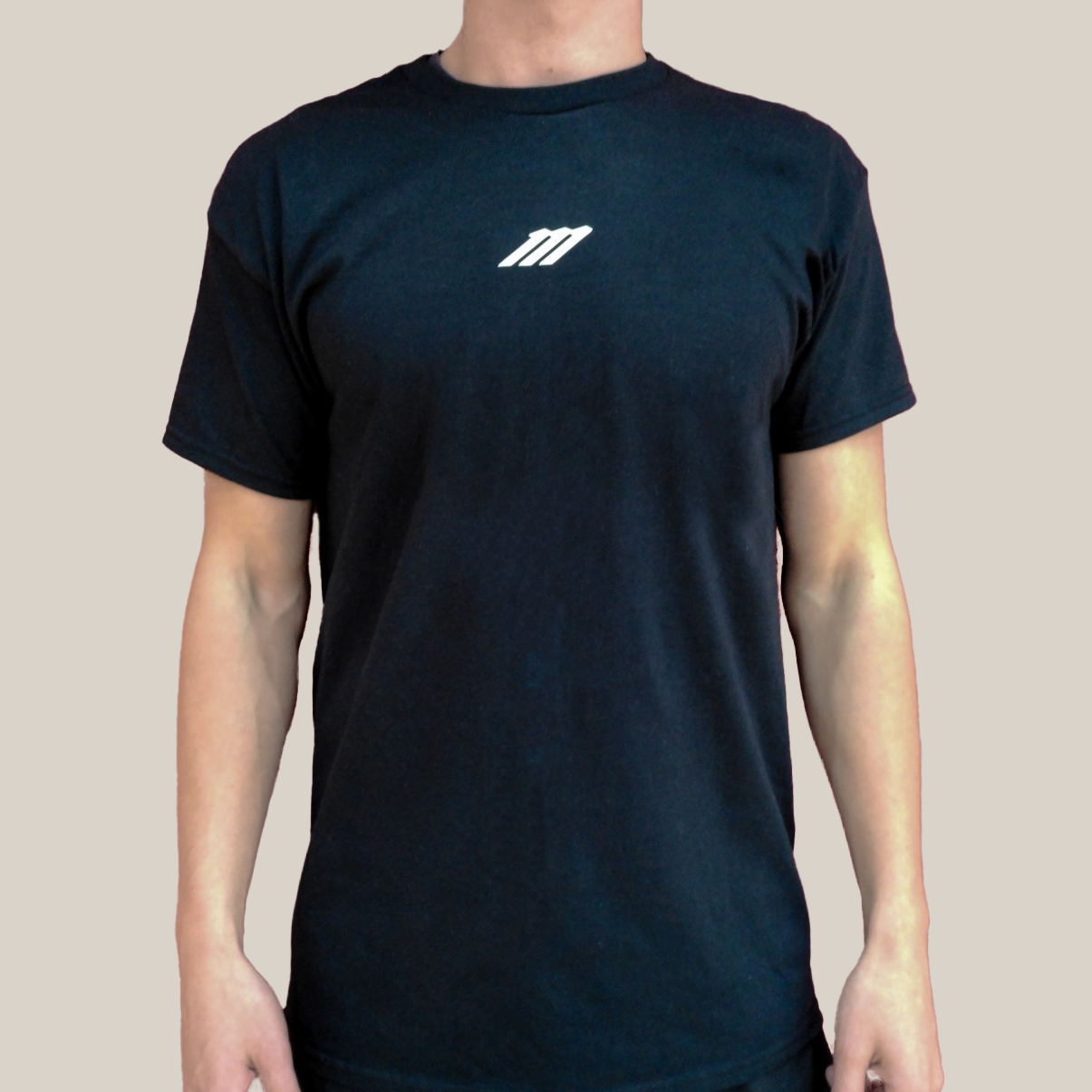 Black t-shirt with a white Motion M logo on a beige background