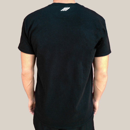 Person wearing a black t-shirt with a Motion M logo on the back against a beige background