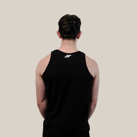 Person wearing a black tank top with a Motion M logo on the back against a beige background