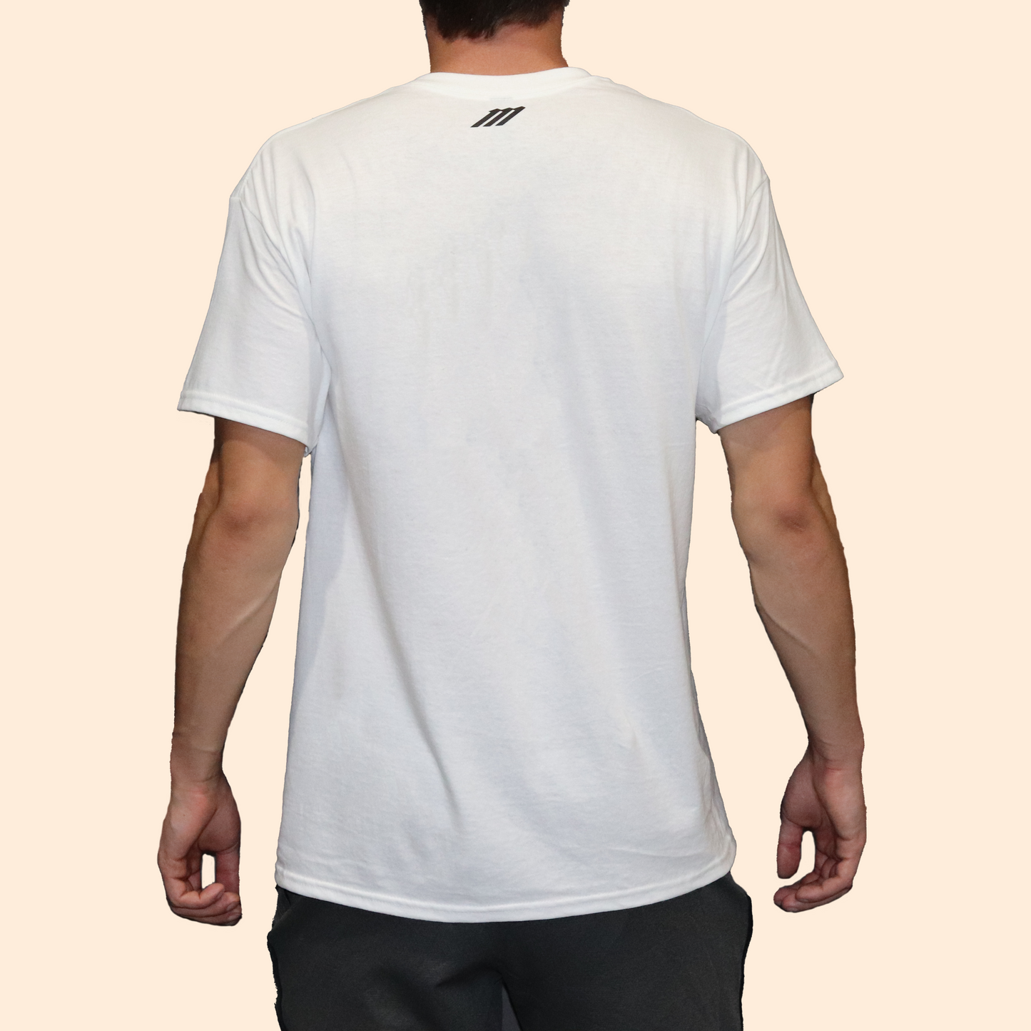 Person wearing a white t-shirt with a brand logo on the back against a beige background