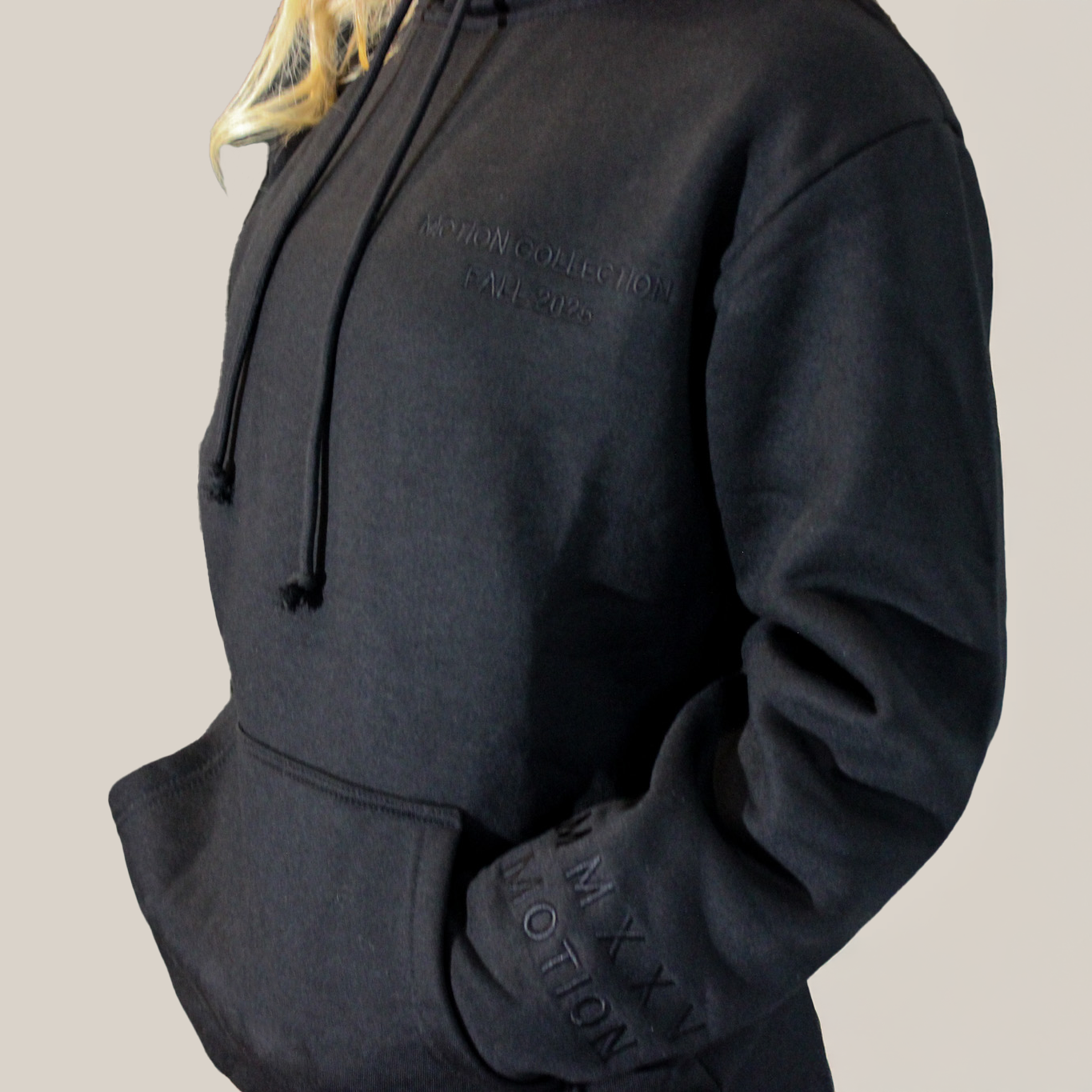 Black hoodie with Motion brand name logo on a beige background
