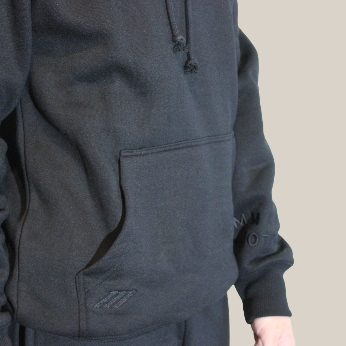 Dark Black Motion hoodie worn by a person on a beige background