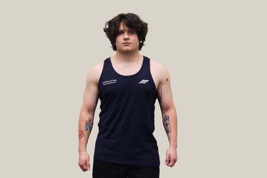 Model wearing a navy tank top with a logo on a beige background