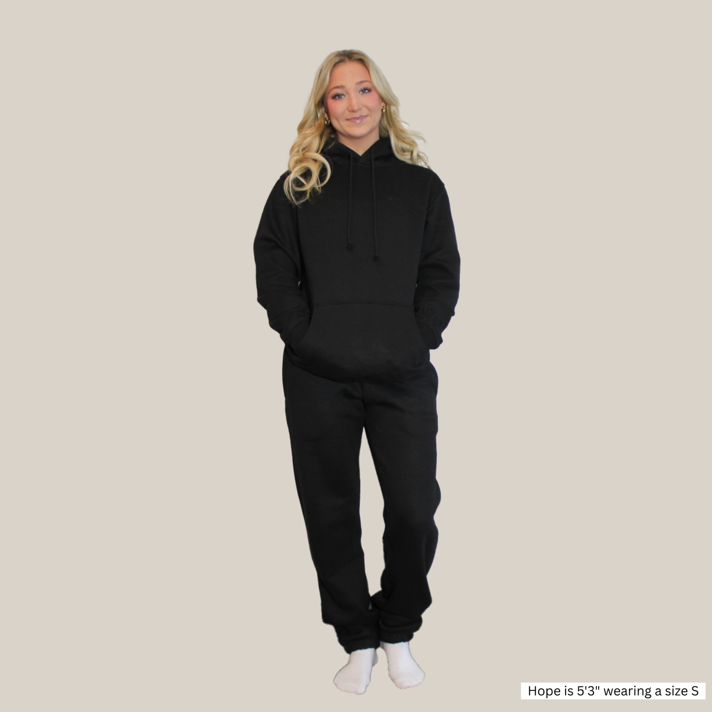 Model wearing a Motion Signature Black Pants and signature motion hoodie