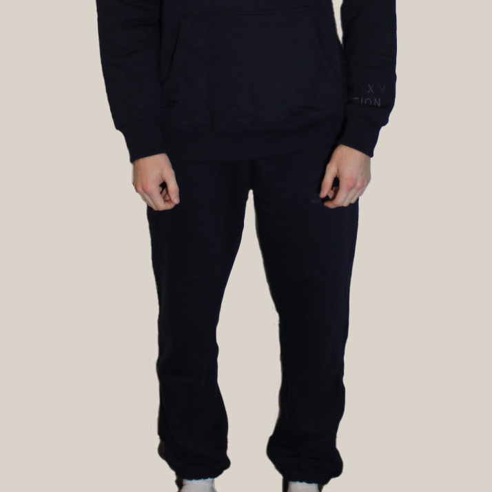 Person wearing a black Motion hoodie and Motion pants on a beige background