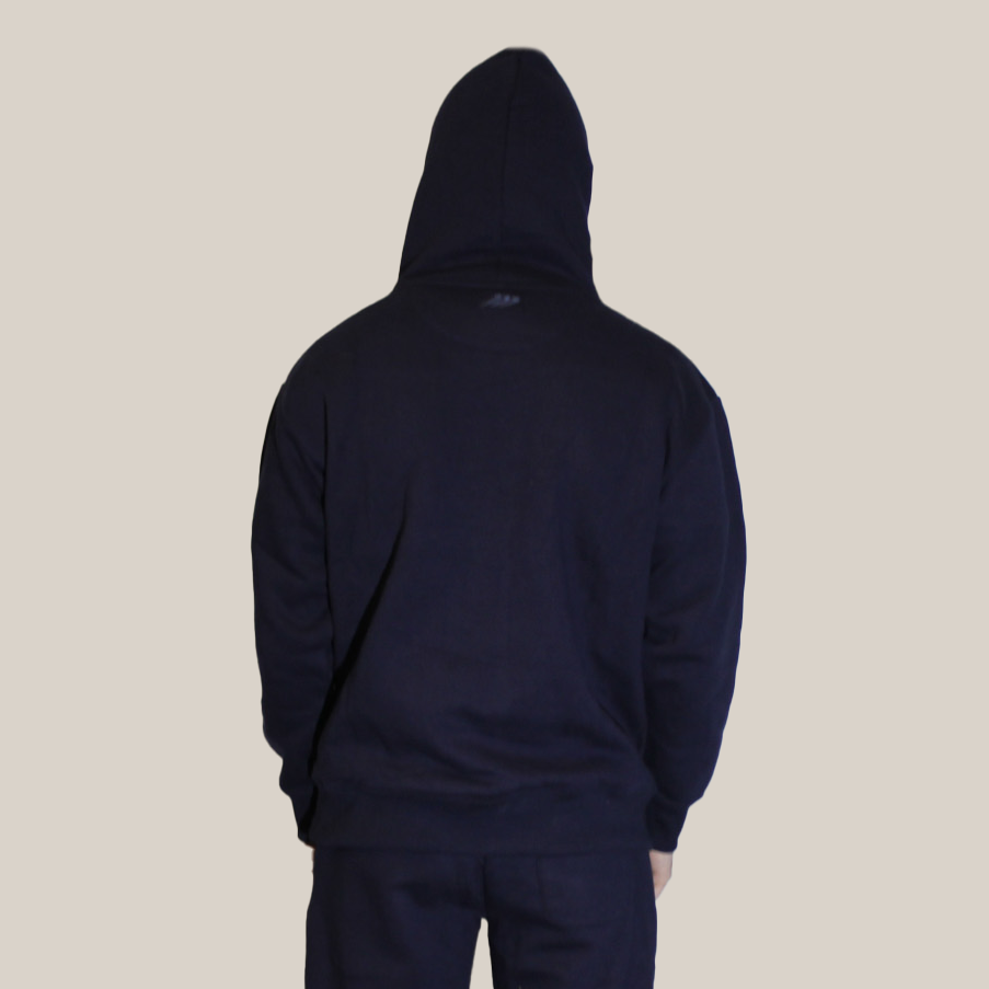 Person wearing a navy blue tracksuit on a beige background with Motion Logo on back neckline